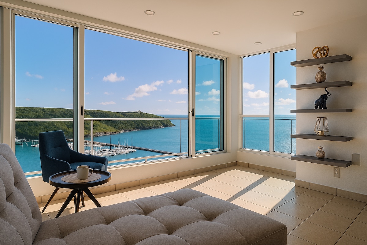 Living room with floor-to-ceiling windows looking out over the Fajardo marina, headland, and Atlantic Ocean
