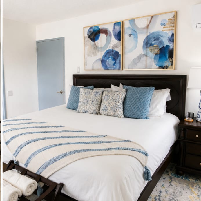 Primary bedroom with king bed and blue abstract artwork